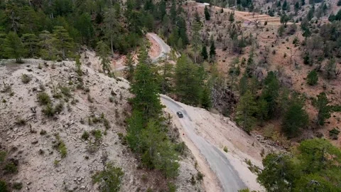 A shot of a drone flying over a beautiful mountain and a mountain road 4k Video stock 213613448