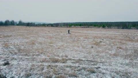 Shot on a drone.A man in a field found metal underground with a metal detector. Video stock 221164766