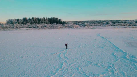Shot on a drone. A single winter hike of a tourist on a frozen river. Stock Footage 222897043