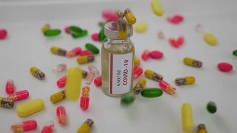 Shot of dropping tablets on covid-19 vaccine bottle, Coronavirus vaccine surr Stock Footage 147697623