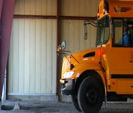Shot of empty schoolbus pulling out of garage Stock Footage 21624358