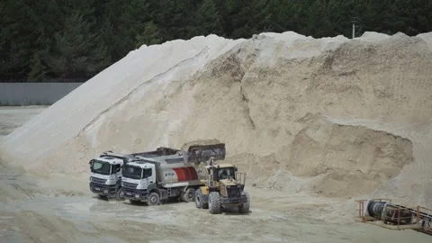Shot of excavator loading sand onto trucks. Heavy industrial machine working in Stock Footage 219950988