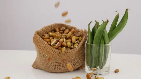 Shot of falling bean seeds on brown jute bag, Glass filled with green beans Stock Footage 159638322