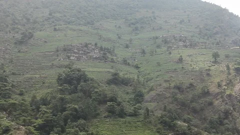Shot focused on small mountain town, then zooms out to show whole mountainside. Stock-Footage 86758124