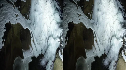 This is a shot of a frozen waterfall running into a frozen cold pond. Shot on Stock Footage 59194706