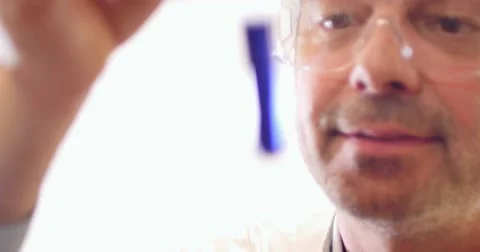 Shot of a funny scientist showing two test tubes with their content in it Stock Footage 48981381