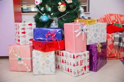 Shot of a group of boxes with presents under a decorated Christmas tree . chr Stock Photos