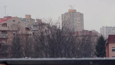 Shot of hail falling with focus changing from city to balcony Stock Footage 90860876