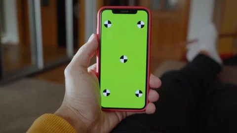 Shot of hands man lying on sofa use hold vertical green screen phone at home Stock Footage 118472734