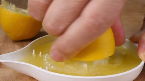 Shot of human hand squeezing lemon juice out of the lemon using manual frui.. Stock Footage 265839127