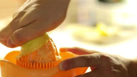 Shot of human hand squeezing lemon juice out of the lemon using manual fruit Vídeo Stock 336588609