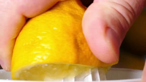 Shot of human hand squeezing lemon juice out of the lemon using manual fruit Stock-Footage 336588618