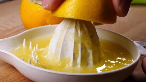 Shot of human hand squeezing lemon juice out of the lemon using manual fruit Stock-Footage 336588634