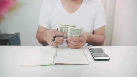 Shot of human hands counting american dollars. a man counts money on a 스톡 동영상 336260975