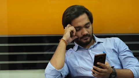 A Shot of an Indian Boy using phone in his office Stock Footage 228554360