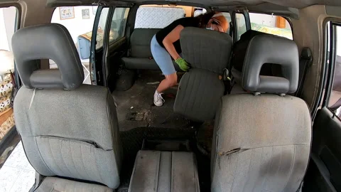 Shot from inside the car of two people removing seats from a van Video stock 172081410