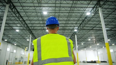 Shot of Inside large commercial warehouse that person in yellow work jacket who 스톡 동영상 304392929