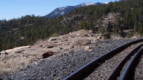Shot inside a moving train with trees and mountains in the background Stock Footage 90023480