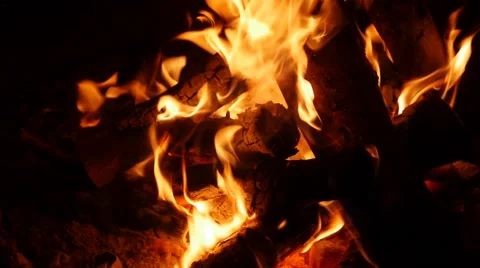 A shot of a large campfire burning at night in camp Stock Footage 54813741