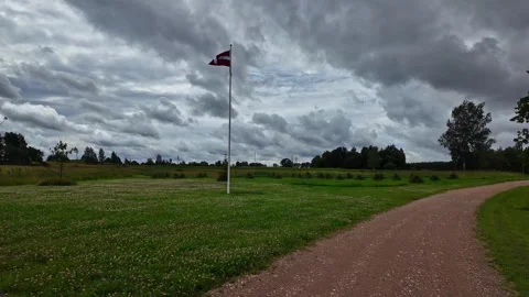 Shot of Latvia Flag waving high under a cloudy sky on a field in Latvia. Stock Footage 281358055