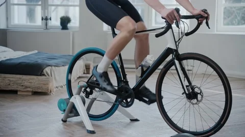 Shot of the legs of a cyclist training on an exercise bike at home Video stock 171116736