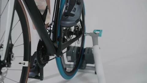 Shot of the legs of a cyclist training on an exercise bike in white studio Stock Footage 171118671