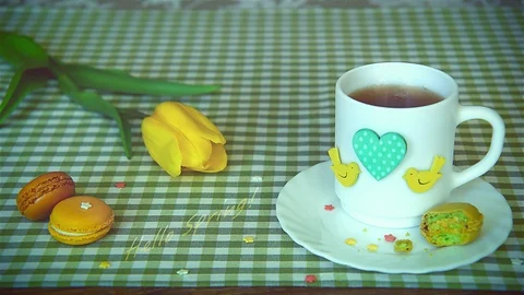 Shot with lettering «Hello Spring!», using yellow tulip, a white cup of tea Vídeos de archivo 86127883