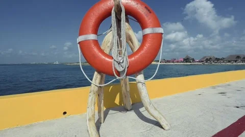 Shot of a lifesaver personal flotation device by the ocean water. Stock Footage 45281596