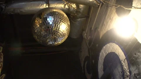 Shot Looking Up at Disco Ball Next to Light in Grungy Restaurant with Graffiti 库存影片 166815505
