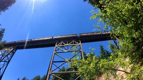 A shot looking up as a train crosses over a wooden bridge over fish creek Vidéo 94053266