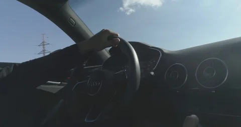 Shot on man arms that holds the wheel of a black sport car with dashboard Stock Footage 100034672