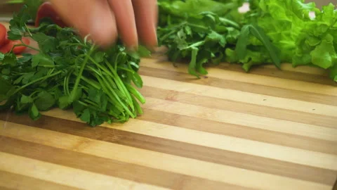 Shot of man chef cutting greens on chopping wooden board Stock Footage 87952257
