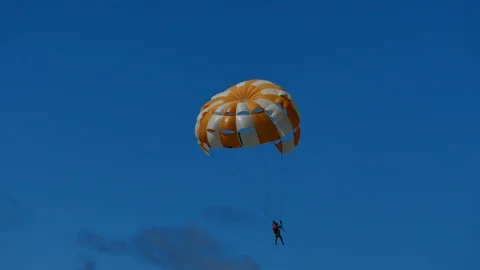 A shot of a man doing parasailing and waving for a moment. Shot filmed in Stock Footage 114604269