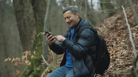 Shot of man uses smarphone in the spring forest smile feel happy technology park Stock Footage 127168438