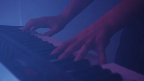 Shot of man's hands playing key, purple light Stock Footage 127134738