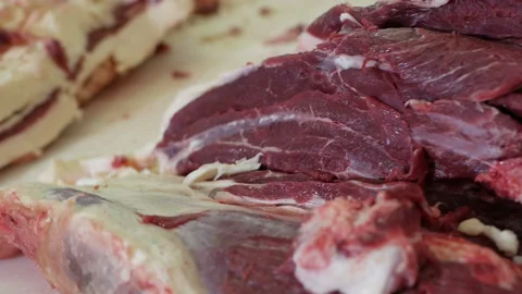 Shot of meatman with a sharp knife in hand separating meat from bones. Stock Footage 144260489