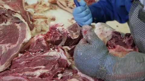 Shot of meatman with a sharp knife in hand separating meat from bones. Stock Footage 144261170