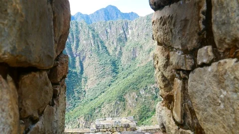 A shot of the mountains through a window in a wall at Macchu Picchu ruins. Stock Footage 100722989