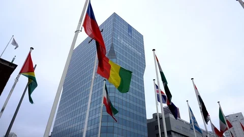 Shot of moving flags with a skyscrape in the background Stock Footage 89783543