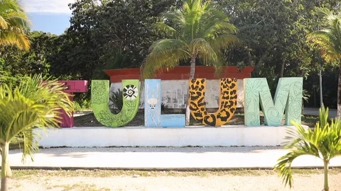Shot Moving Towards Big Tulum Sign and Then Spinning Around with Palm Trees Stock Footage 121731459