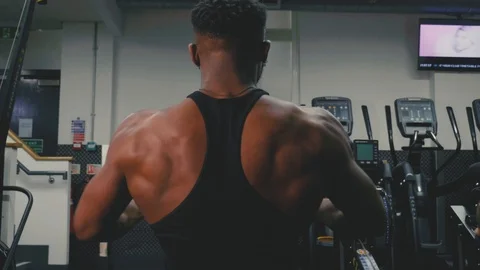 Shot of a muscular man's back using a rowing machine in the gym Stock Footage 89577422