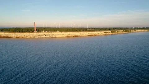Shot of the old lighthouse and the park of wind generators on the peninsula Video stock 87420586