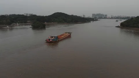 A shot over a river along which a large cargo ship is sailing Stock Footage 114126301