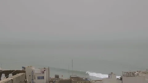 Shot overlooking rooftops with ocean swell in the background Stock Footage 100244044