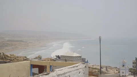 Shot overlooking rooftops with the taghazout beach in the background Stock Footage 100244525