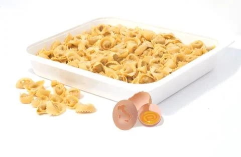 A shot of pasta in the form of seashell served in a square white bowl and egg Stock Photos