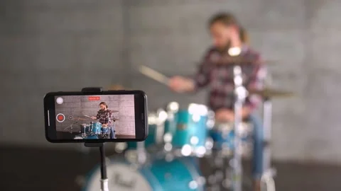 Shot of Phone doing video of man. Man is making video of his playing the drums. Stock Footage 155554615