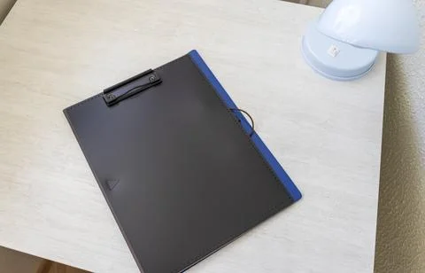 Shot of the plastic folder on the office desk with paper clip holder on the.. Stock Photos