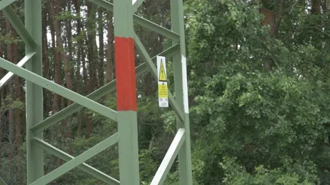 Shot of a pole with power lines. Part of the shot points to the warning symbol 動画素材 131828896