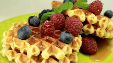 Shot of Pouring maple Syrup Onto waffle With mix Berries. Stock-Footage 336589386